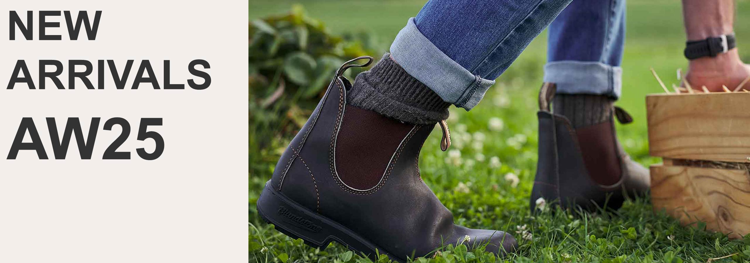 Brown shoes worn with rolled-up jeans on grass, with 'NEW ARRIVALS AW25' text on the left.