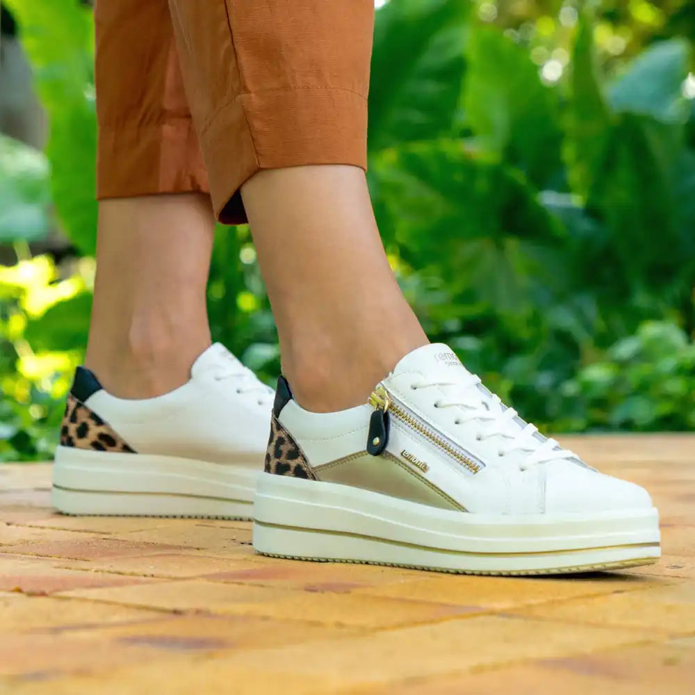 woman leaning towards a tree with brown boots