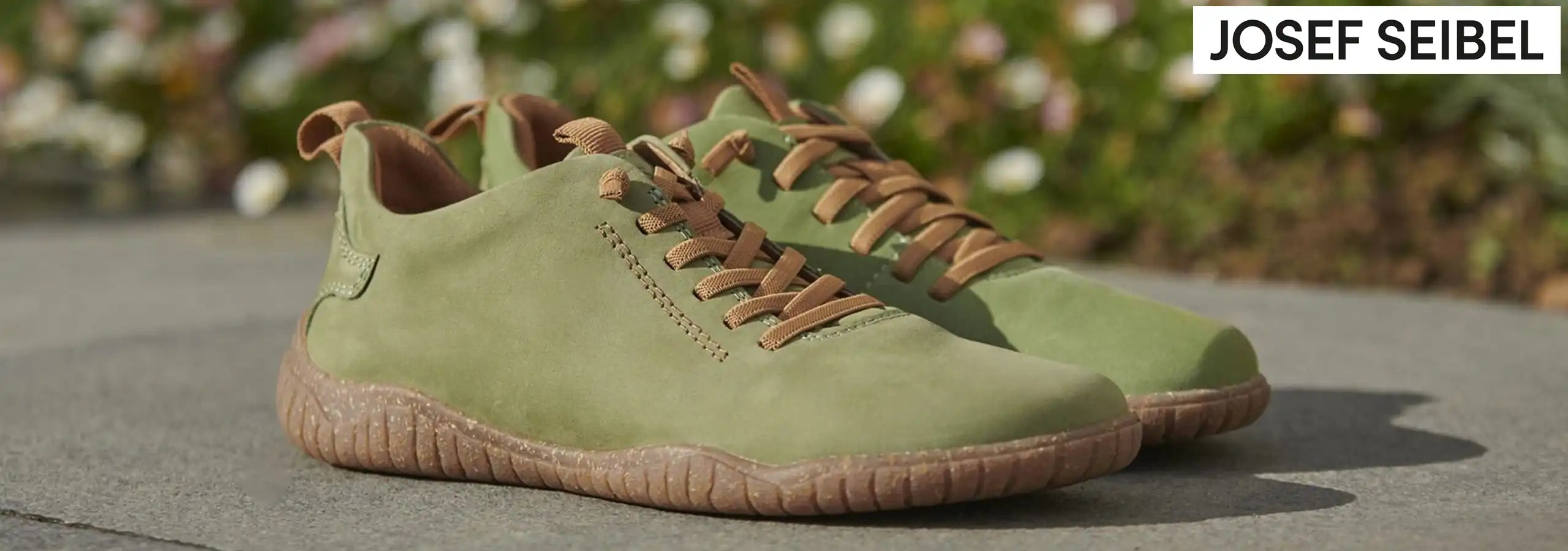 Green shoes with brown accents on a blurred natural background, featuring the brand 'Josef Seibel'.